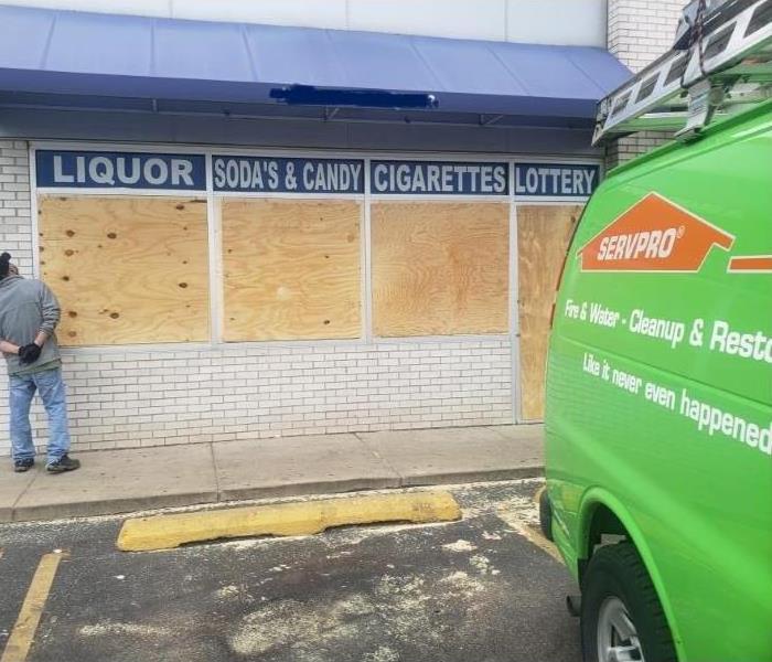 boarded up business with SERVPRO van